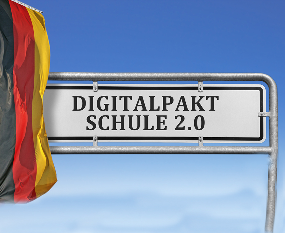 Symbolbild mit Schild wo "Digitalpakt Schule 2.0" draufsteht und deutsche Fahne zu sehen ist. Im Hintergrund blauer Himmel.