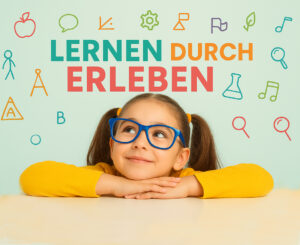 Überschrift "Lernen durch Erleben": MINT-Unterricht: Kleines Mädchen mit Brille, das auf bunte Coding- und TExt-Symbole über ihrem Kopf schaut.